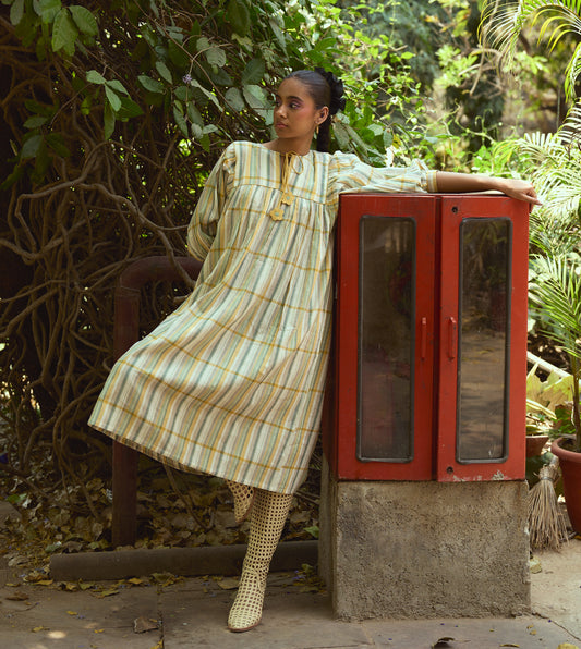 Striped khadi cotton dress with flower-tasseled ties and ¾ sleeves, offering a relaxed and elegant silhouette.