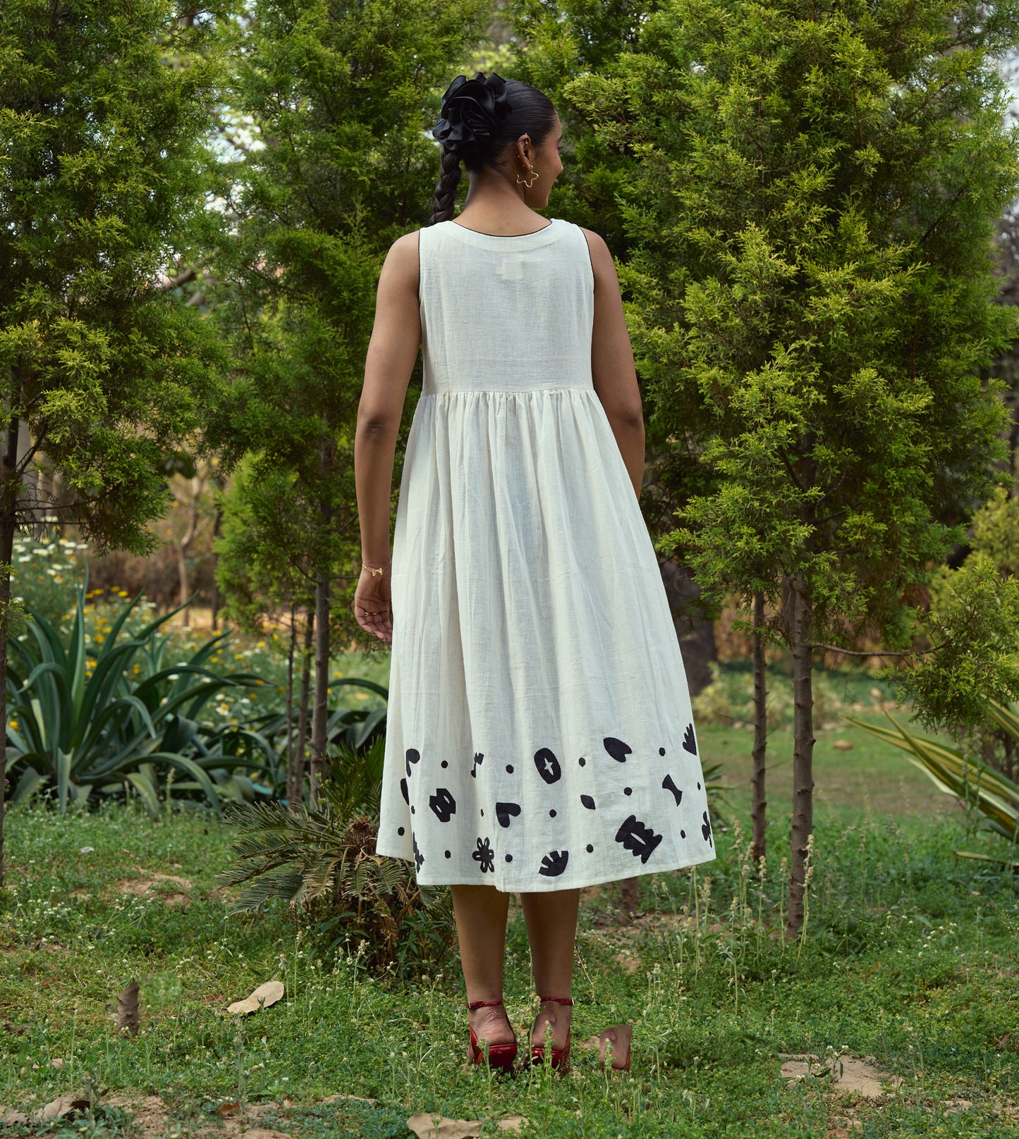 Sleeveless kala cotton midi dress with hand-stitched appliqué patterns and pockets, designed for versatile styling.