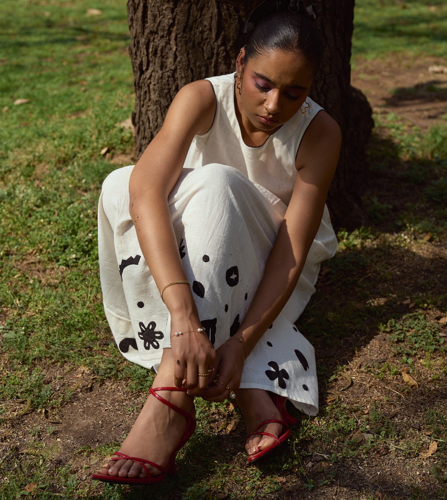 Sleeveless kala cotton midi dress with hand-stitched appliqué patterns and pockets, designed for versatile styling.