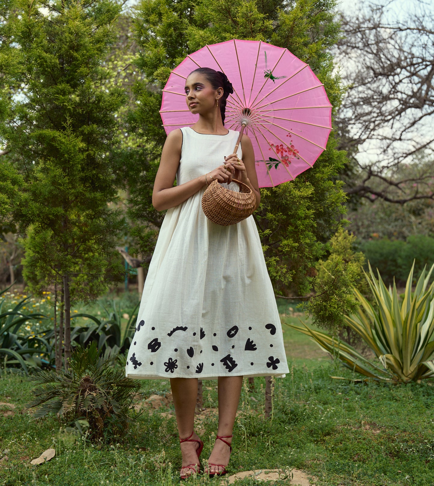 Sleeveless kala cotton midi dress with hand-stitched appliqué patterns and pockets, designed for versatile styling.