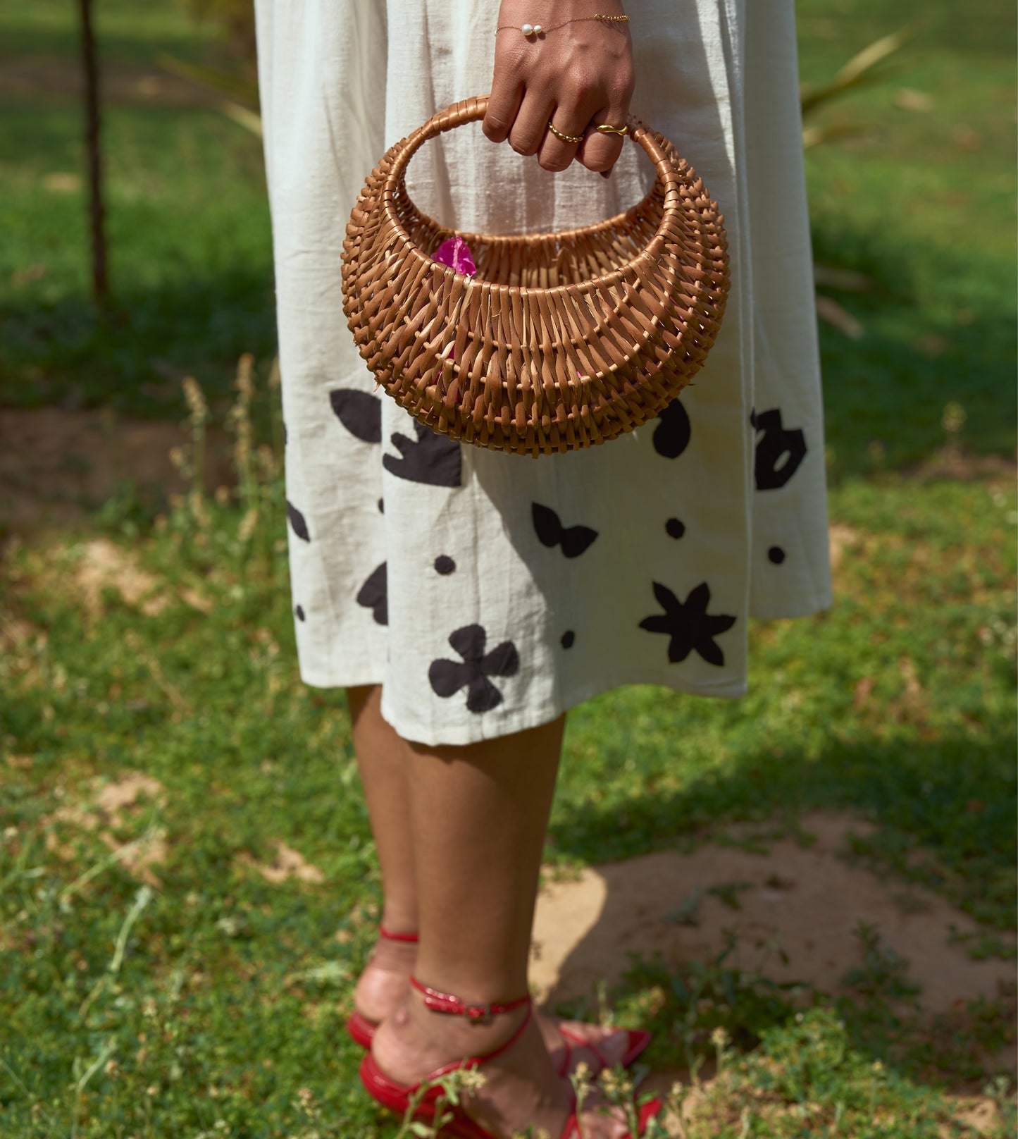 Sleeveless kala cotton midi dress with hand-stitched appliqué patterns and pockets, designed for versatile styling.