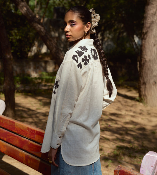 Full-sleeve kala cotton shirt with hand-stitched appliqué patterns and corozo buttons, relaxed fit.