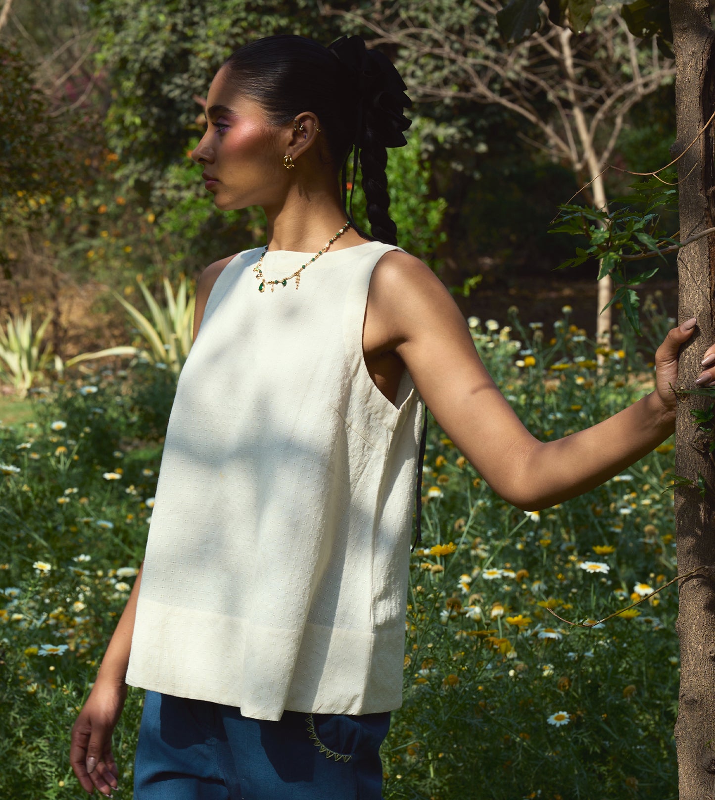 Sleeveless khadi cotton trapeze top with a brass button closure, lightweight and breathable.