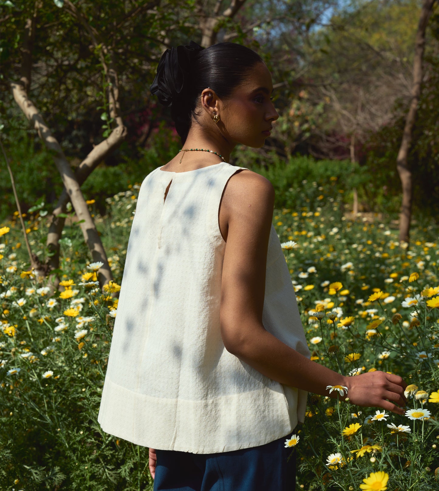 Sleeveless khadi cotton trapeze top with a brass button closure, lightweight and breathable.
