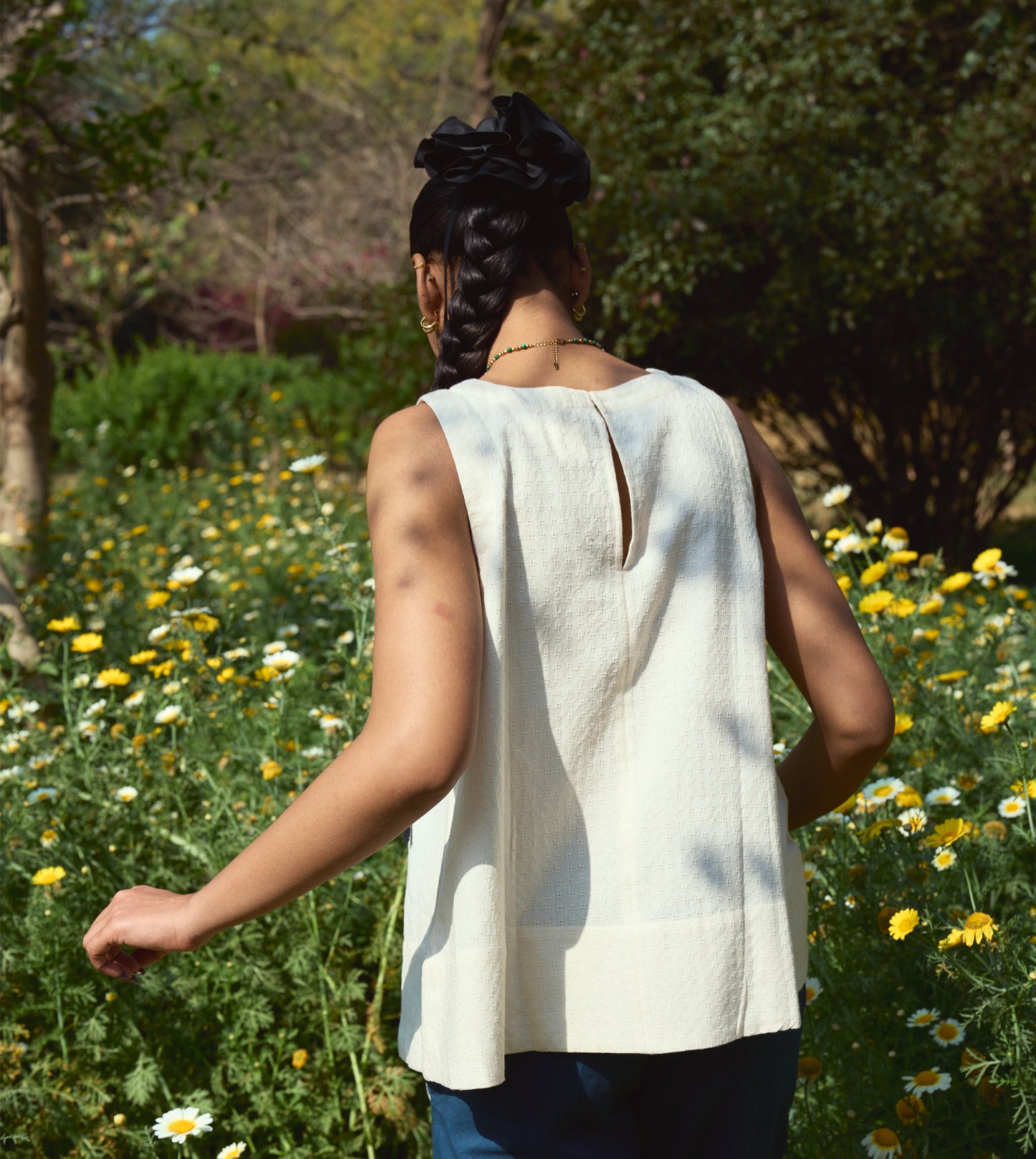 Sleeveless khadi cotton trapeze top with a brass button closure, lightweight and breathable.