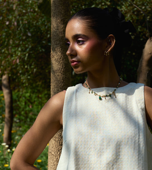 Sleeveless khadi cotton trapeze top with a brass button closure, lightweight and breathable.