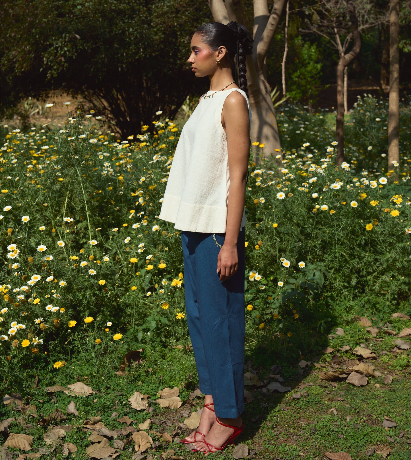 High-waisted thick cotton pants with embroidered pockets, brass button closure, and zippered fly.