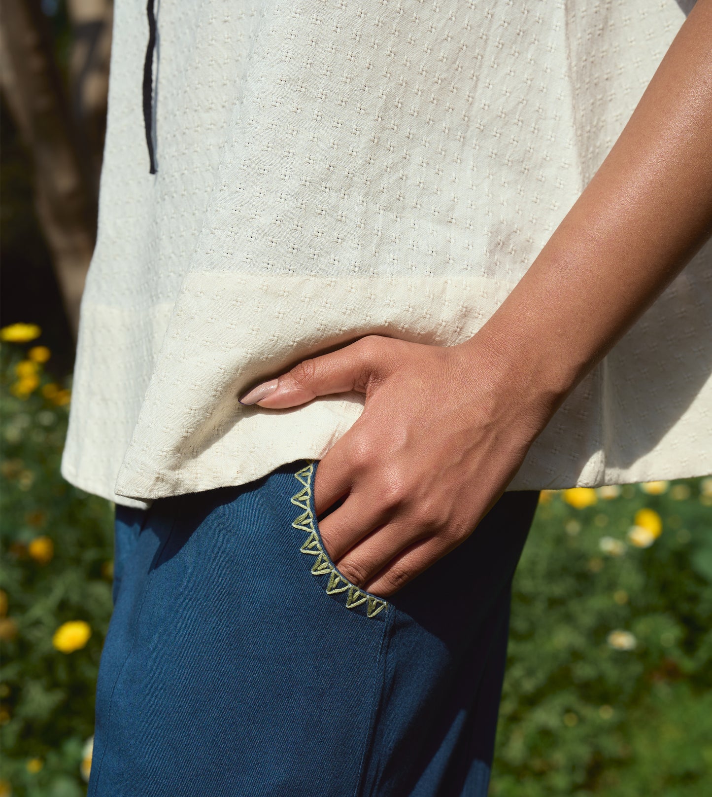 High-waisted thick cotton pants with embroidered pockets, brass button closure, and zippered fly.