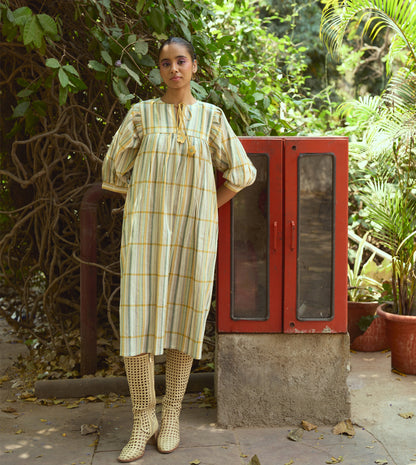 Striped khadi cotton dress with flower-tasseled ties and ¾ sleeves, offering a relaxed and elegant silhouette.