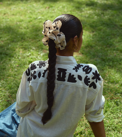 Full-sleeve kala cotton shirt with hand-stitched appliqué patterns and corozo buttons, relaxed fit.