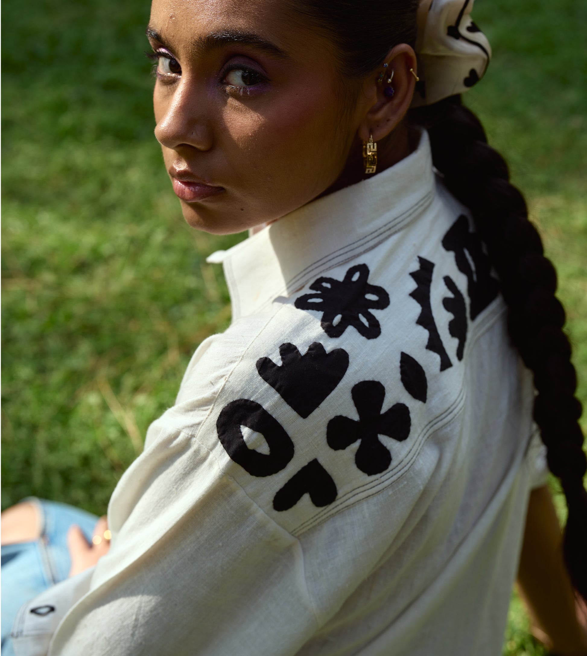 Full-sleeve kala cotton shirt with hand-stitched appliqué patterns and corozo buttons, relaxed fit.