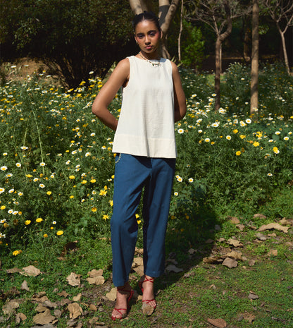 High-waisted thick cotton pants with embroidered pockets, brass button closure, and zippered fly.