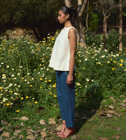 High-waisted thick cotton pants with embroidered pockets, brass button closure, and zippered fly.